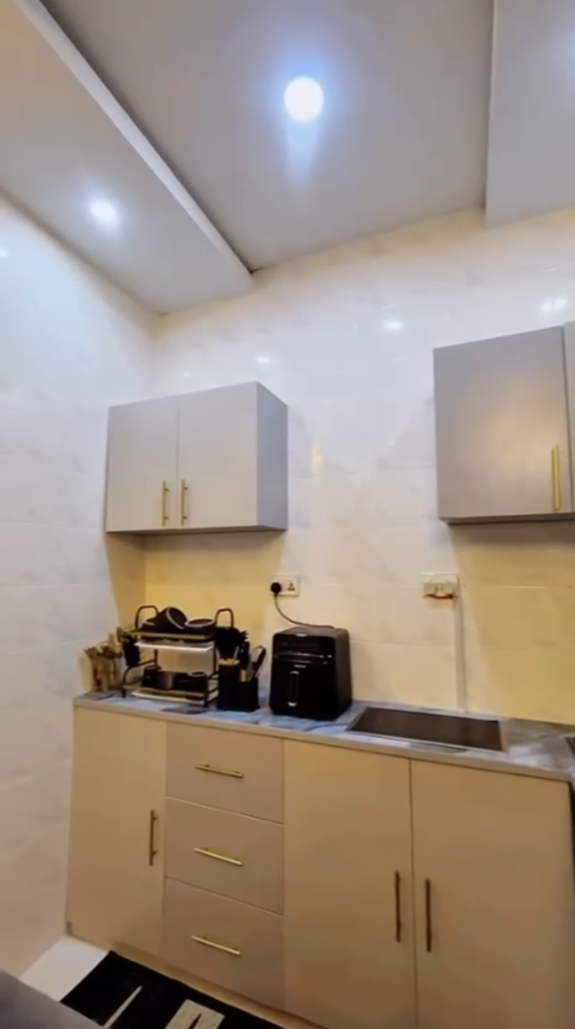 Kitchen cabinets, sink, and countertop appliances at Laimon Apartment