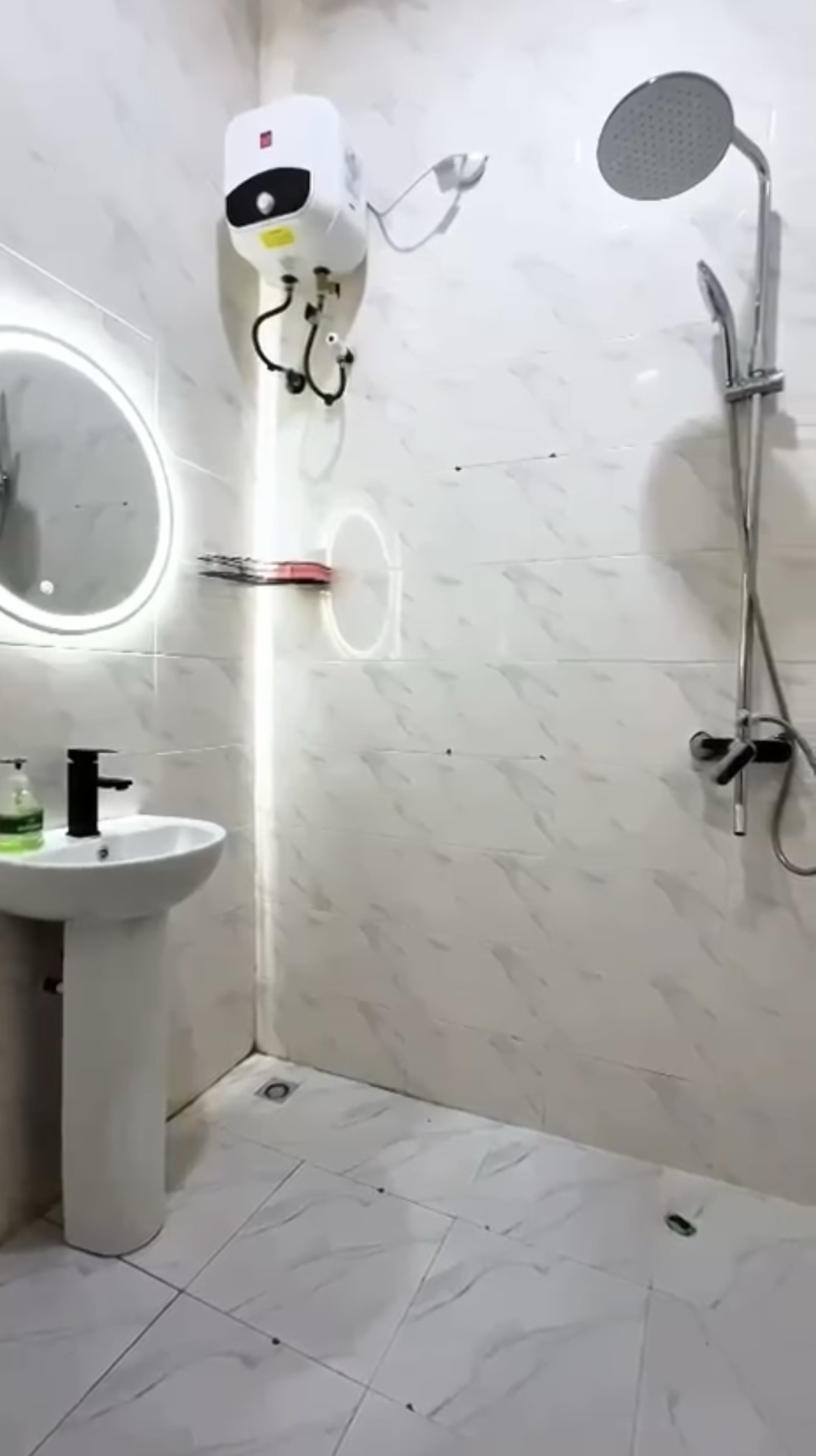 Marble-look bathroom with rainfall shower and illuminated mirror